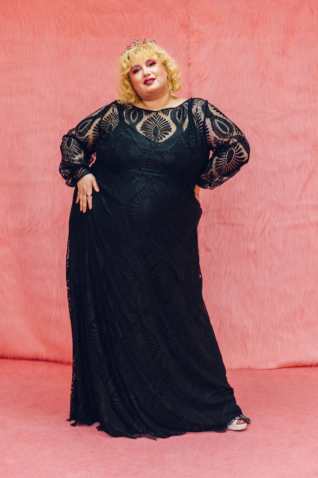 A person wearing a black wedding gown with lacy detail.