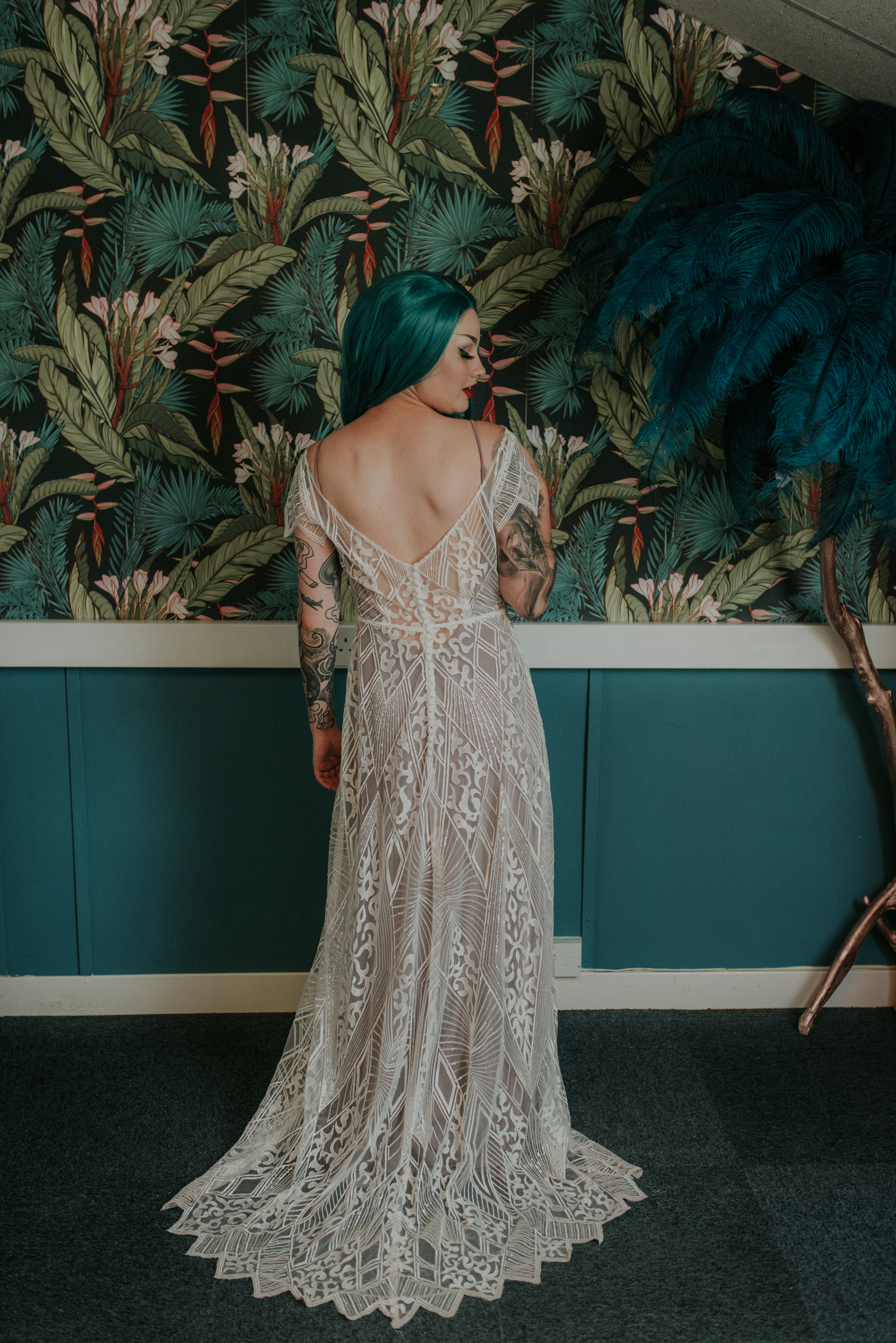 A person wearing an elaborate white lacey wedding gown.