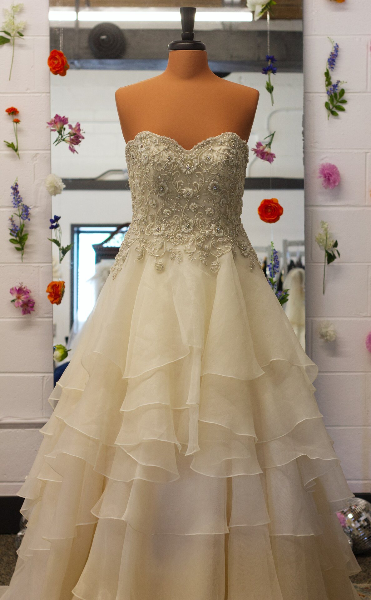 A champagne-colored ballgown with colored beading details.
