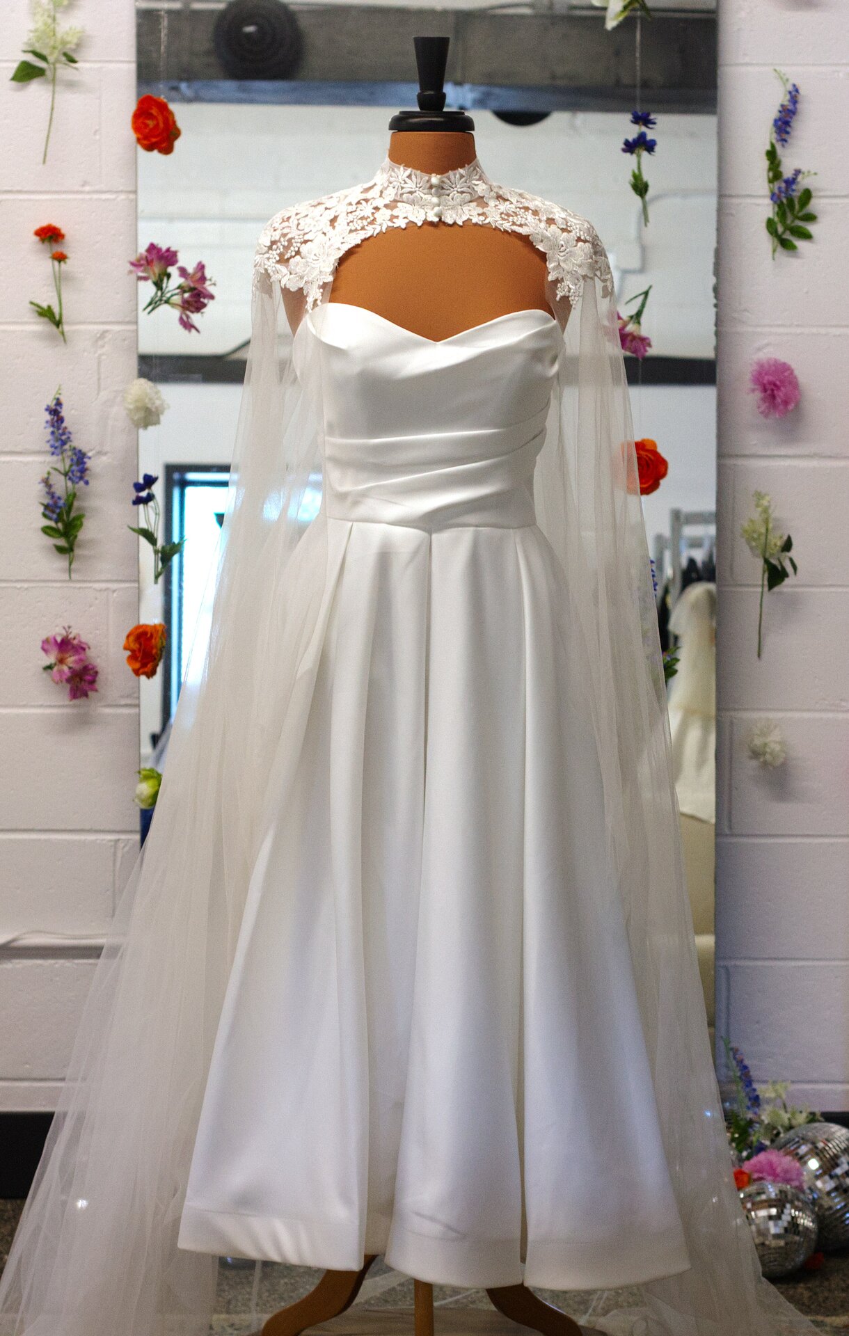 A white tea-length dress with a cape.